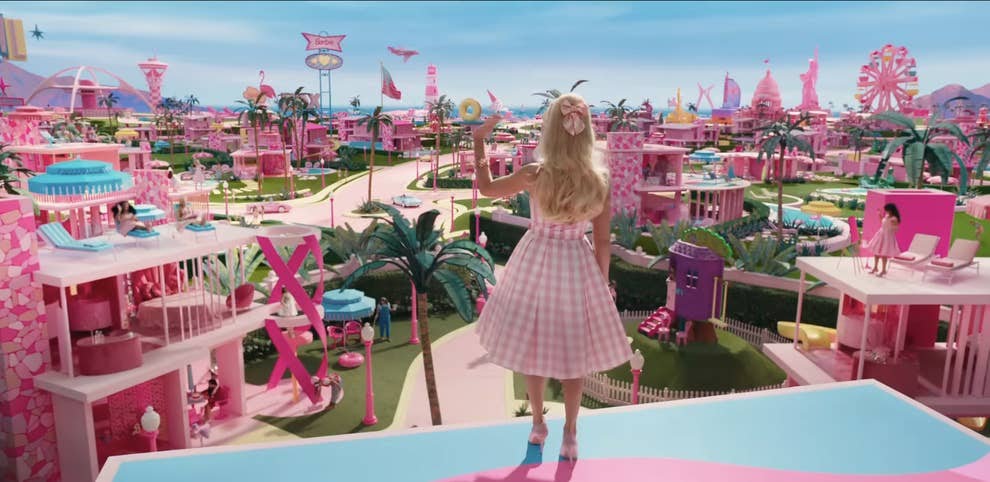 Margot Robbie en Barbie qui surplombe le pays onirique de BarbieLand